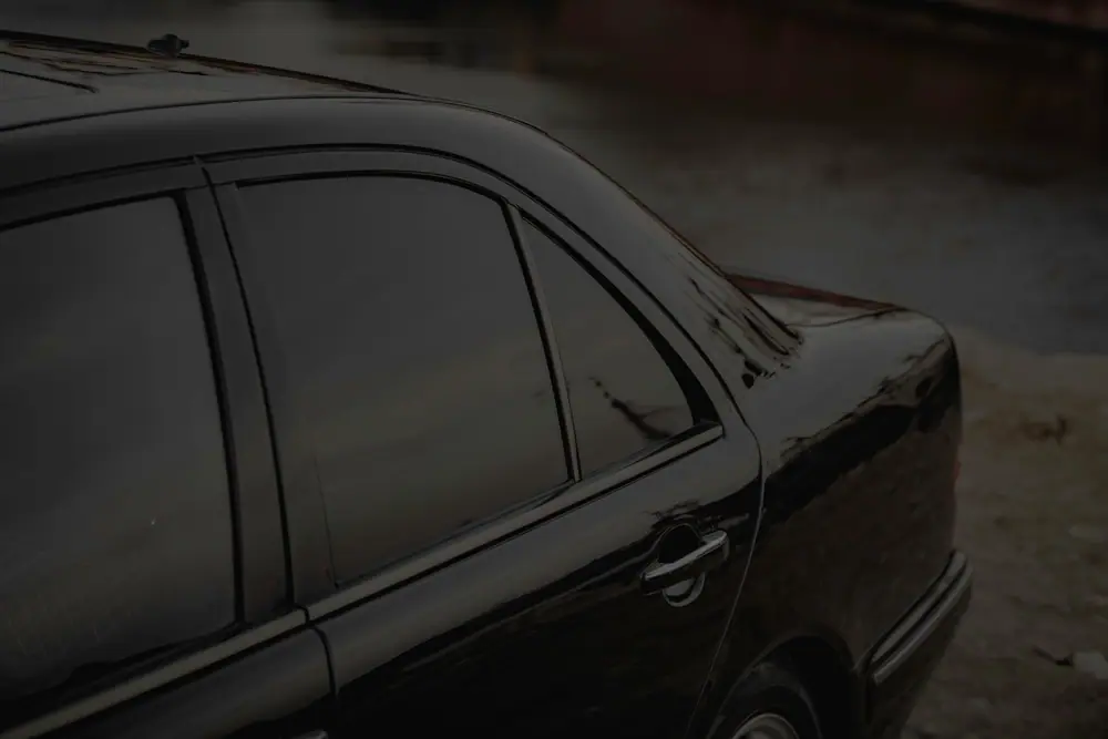 Dark sedan with fully tinted windows at dusk