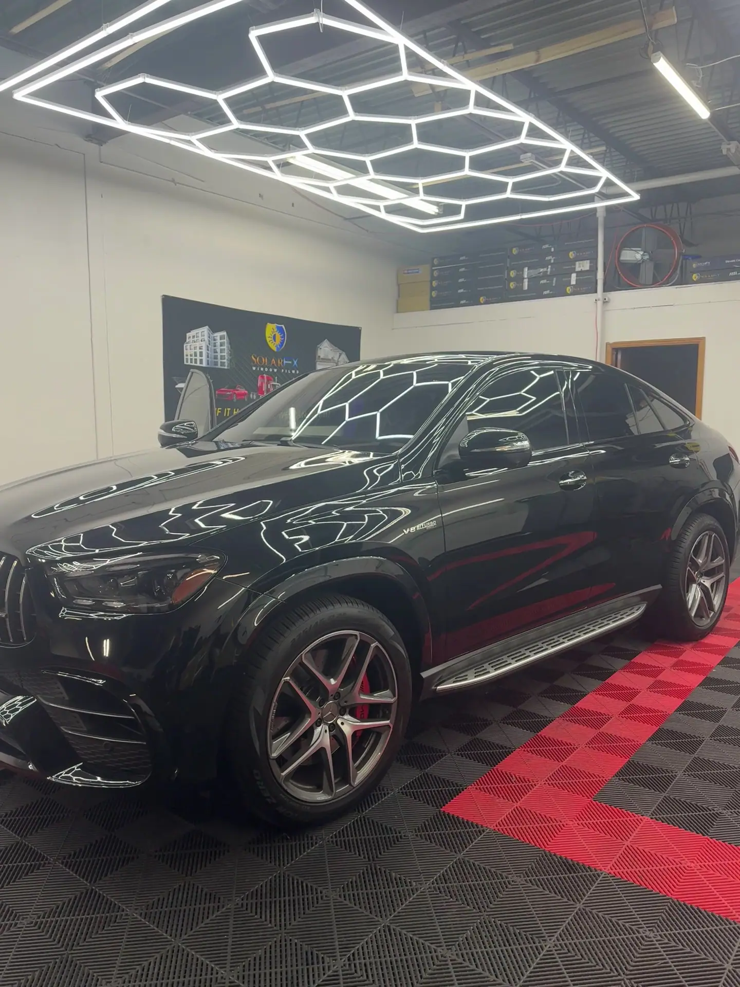 Black Mercedes GLE coupe with tinted windows in the shop bay