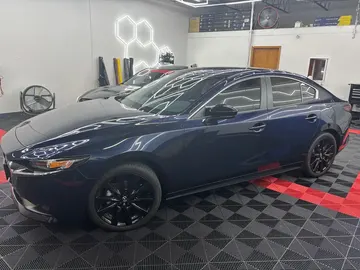 Navy sedan with every window tinted, in the bay