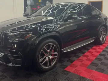 Black Mercedes coupe SUV with tinted glass under hexagon lights