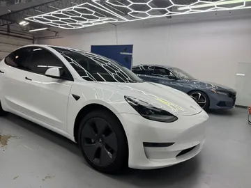 White Tesla Model 3 with tinted side and rear windows in the bay